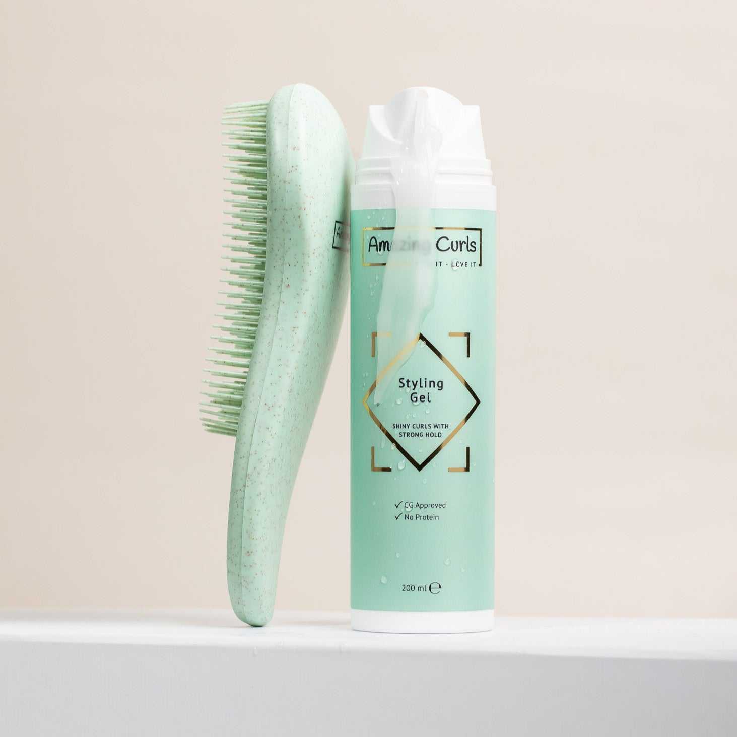 Styling Gel van Amazing Curls naast een mintkleurige borstel, krullenproducten voor krullendhaar en cgmethode 200 ml