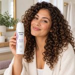 Vrouw met krullend haar toont Amazing Curls All-in-One Treatment